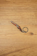 12 gauge shotgun keyring on wooden background with visible twin-barrel design, compact gamer accessory and collectible keychain loop