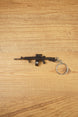 AK-12 rifle keyring with drum magazine on a wooden surface, showing the full metal gamer collectible with chain and ring attached