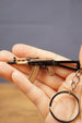 AKS-74U rifle keyring held in hand for scale, showing the compact metal gamer keychain with silver ring and detailed tactical styling