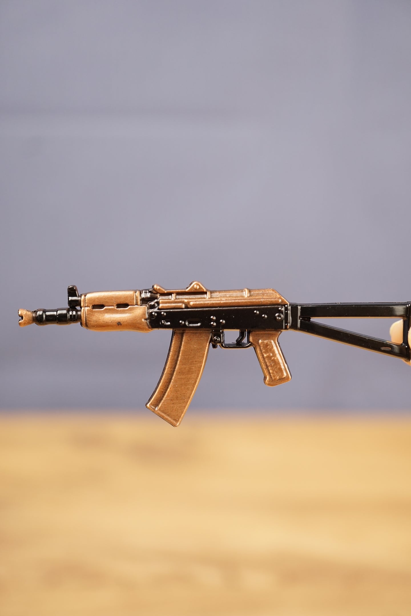 Close-up side view of the AKS-74U rifle keyring showing bronze magazine, black receiver and compact tactical gamer collectible design