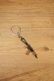 AKS-74U metal rifle keychain displayed vertically on a wooden background, ideal as a tactical gaming gift or backpack charm
