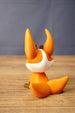 Rear view of an orange Ancient Kitsuu-inspired fox figure showing its oversized ears, white neck marking, and curled tail.