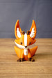 Front view of an orange and white Ancient Kitsuu-inspired fox figure with tall ears, brown antlers, paws, and nose.