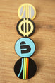 Arc Raiders inspired pin set arranged vertically on a wooden surface, featuring blue, yellow, grey, black, and multicolor round pin designs.