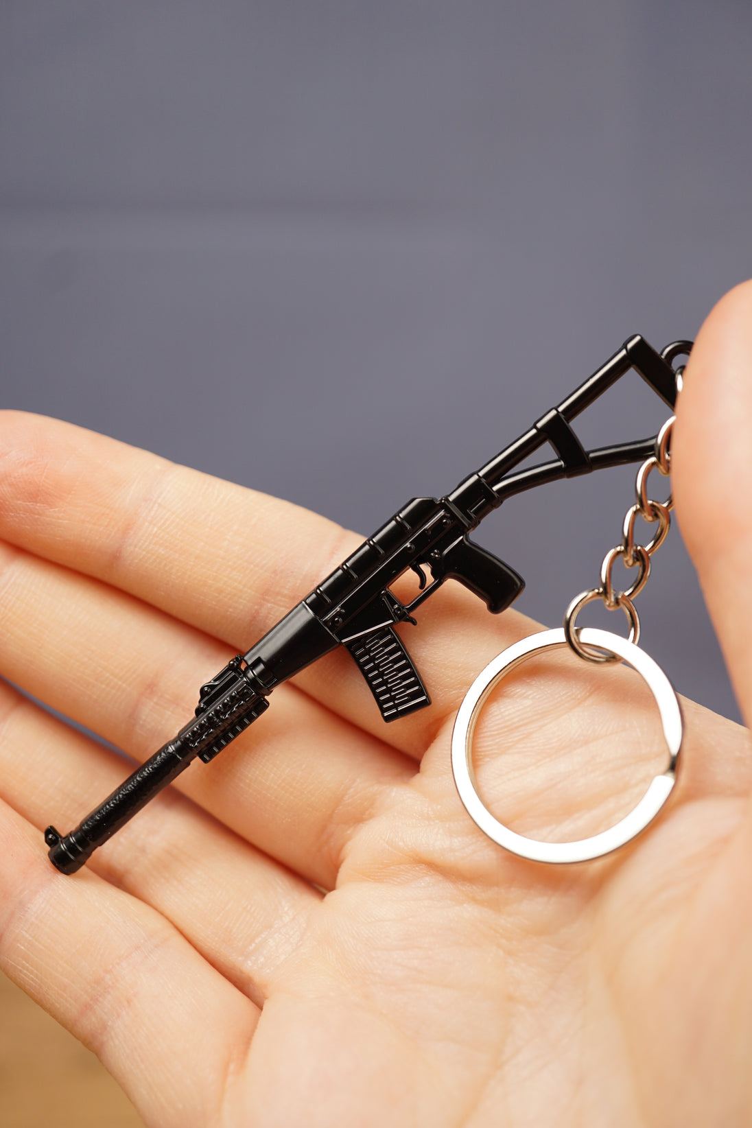 AS Val inspired rifle keychain displayed in hand with silver keyring, black finish and compact tactical gamer accessory design