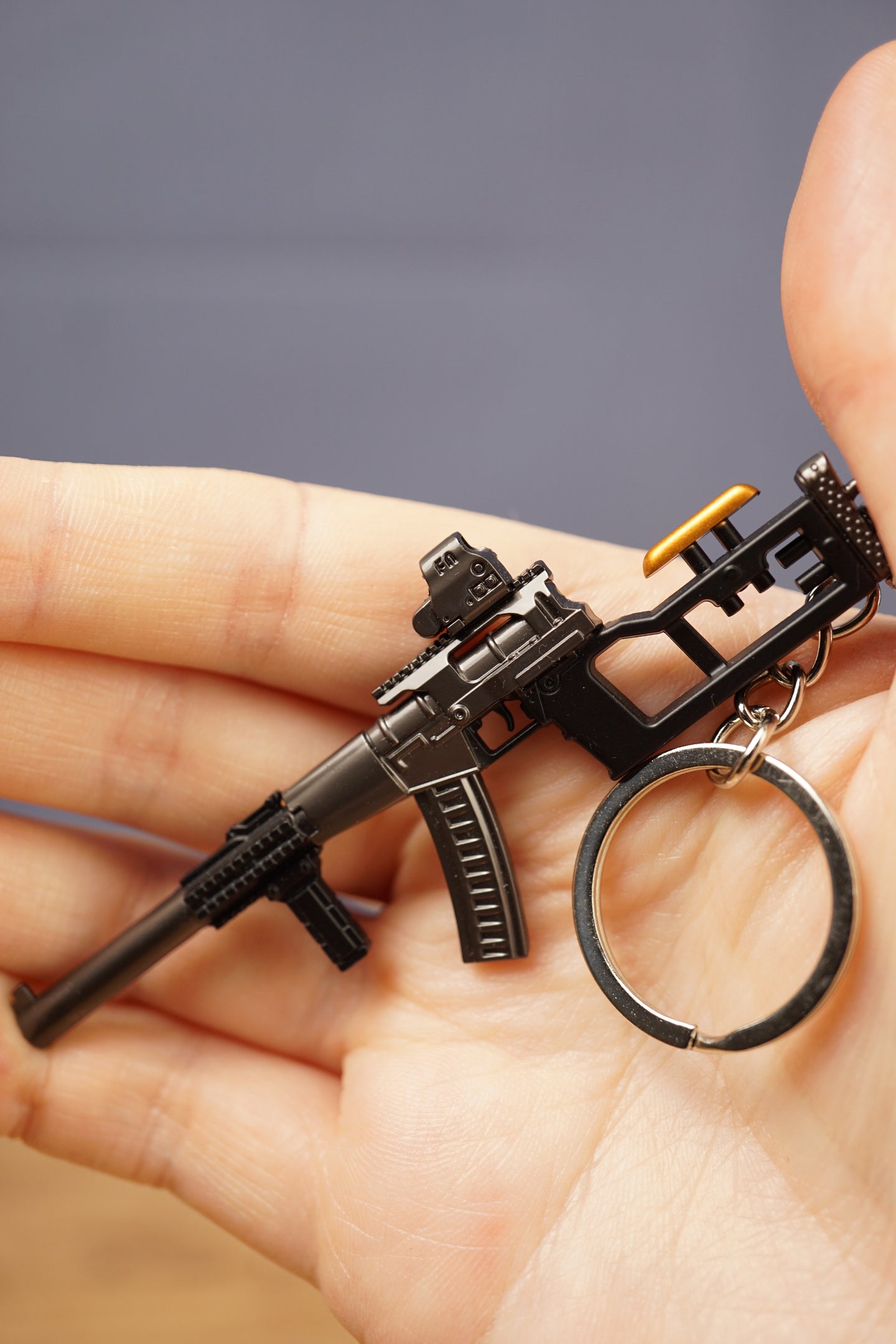 Detailed AS Val style keychain held in hand, showing metal keyring, compact rifle frame and tactical accessory details
