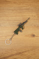 Angled AUG rifle keyring on a wooden background with tactical scope, green stock, metallic barrel and attached silver key ring