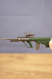 Side view of detailed AUG-style rifle keyring showing green bullpup stock, metal barrel, mounted optic and miniature collectible finish