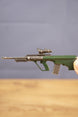 Side view of detailed AUG-style rifle keyring showing green bullpup stock, metal barrel, mounted optic and miniature collectible finish