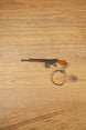 Base SA58 FAL battle rifle keychain with brown stock, metal alloy body and circular keyring shown on a wooden tabletop