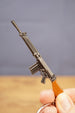 Close-up of base SA58 FAL rifle keychain held in hand, showing magazine, barrel, trigger guard and brown stock detail