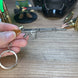 Close-up of SA58 FAL keychain showing detailed receiver and gunmetal finish