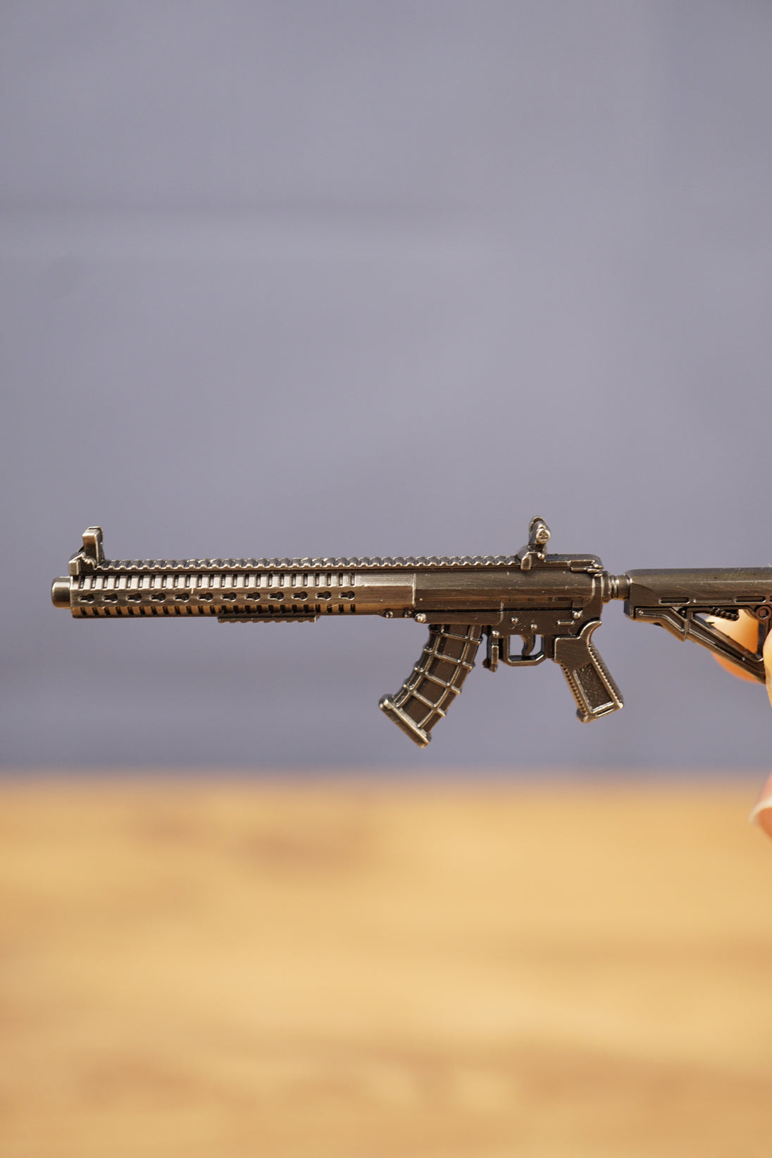 Close-up side view of the MK47 metal rifle keyring showing engraved details, magazine, stock and tactical rail design