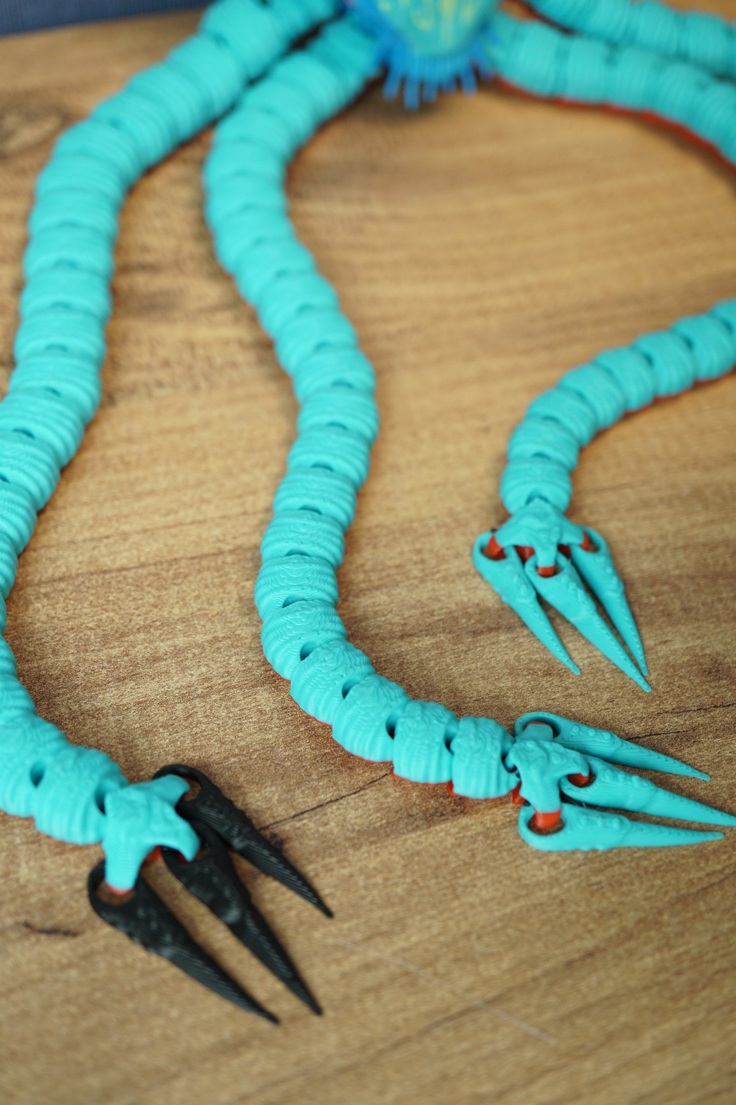 Close-up of Collector Leviathan articulated tentacles with ribbed segments and sharp claw tips in turquoise and black