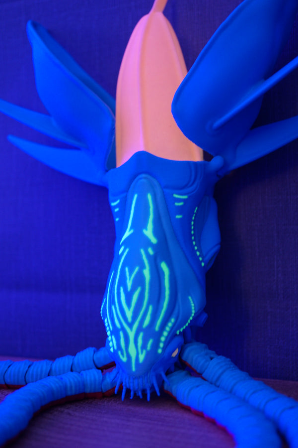 Collector Leviathan figure under UV lighting with glowing face pattern, blue body, pink head crest, and deep-sea creature design