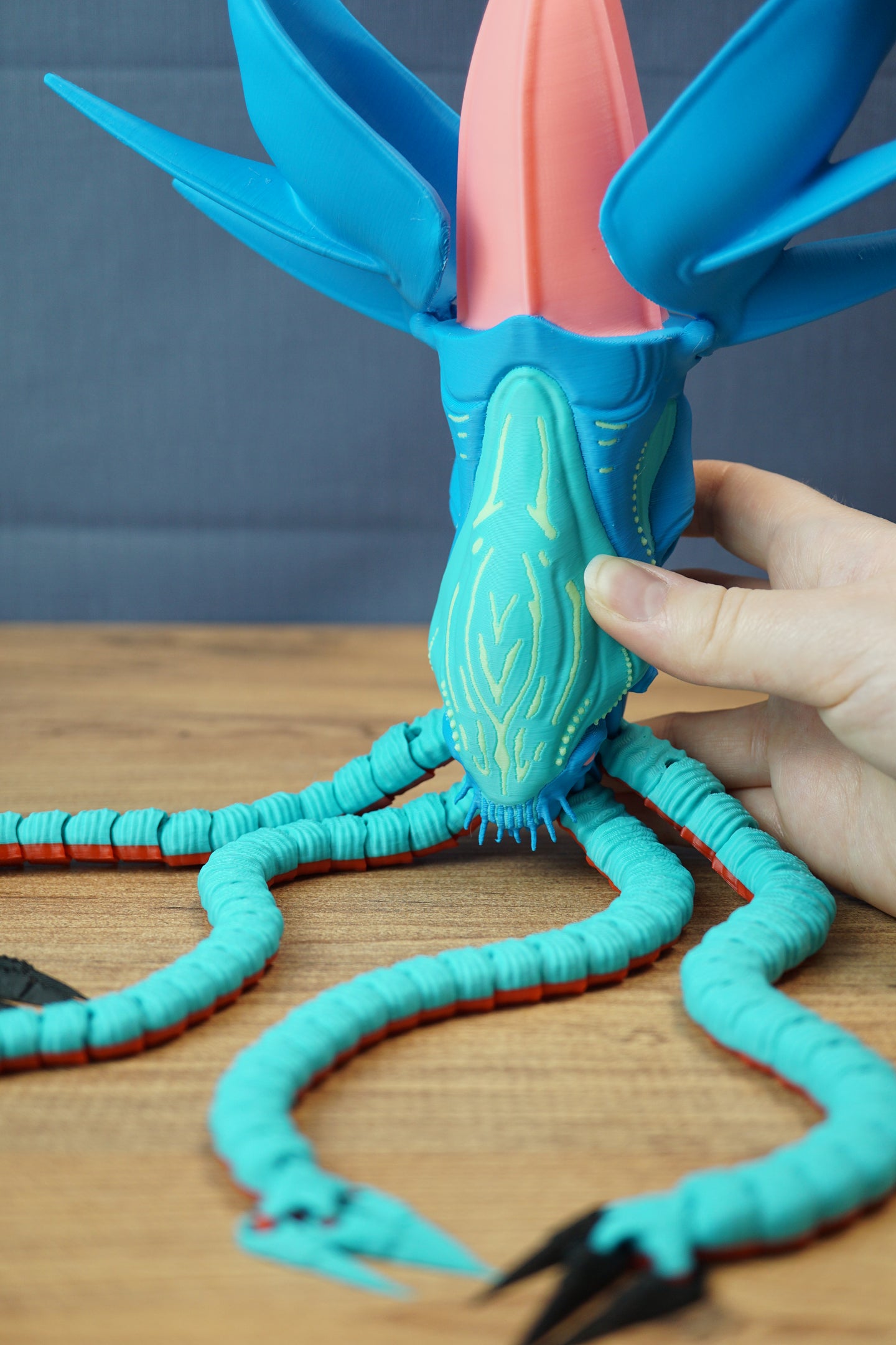 Hand holding Collector Leviathan figure to show scale, opening head, glow face markings, and articulated tentacle display