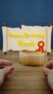Hands holding a custom Happy Birthday Noob quest scroll cake topper with clear acrylic sticks, ready to place into a gamer birthday cake.