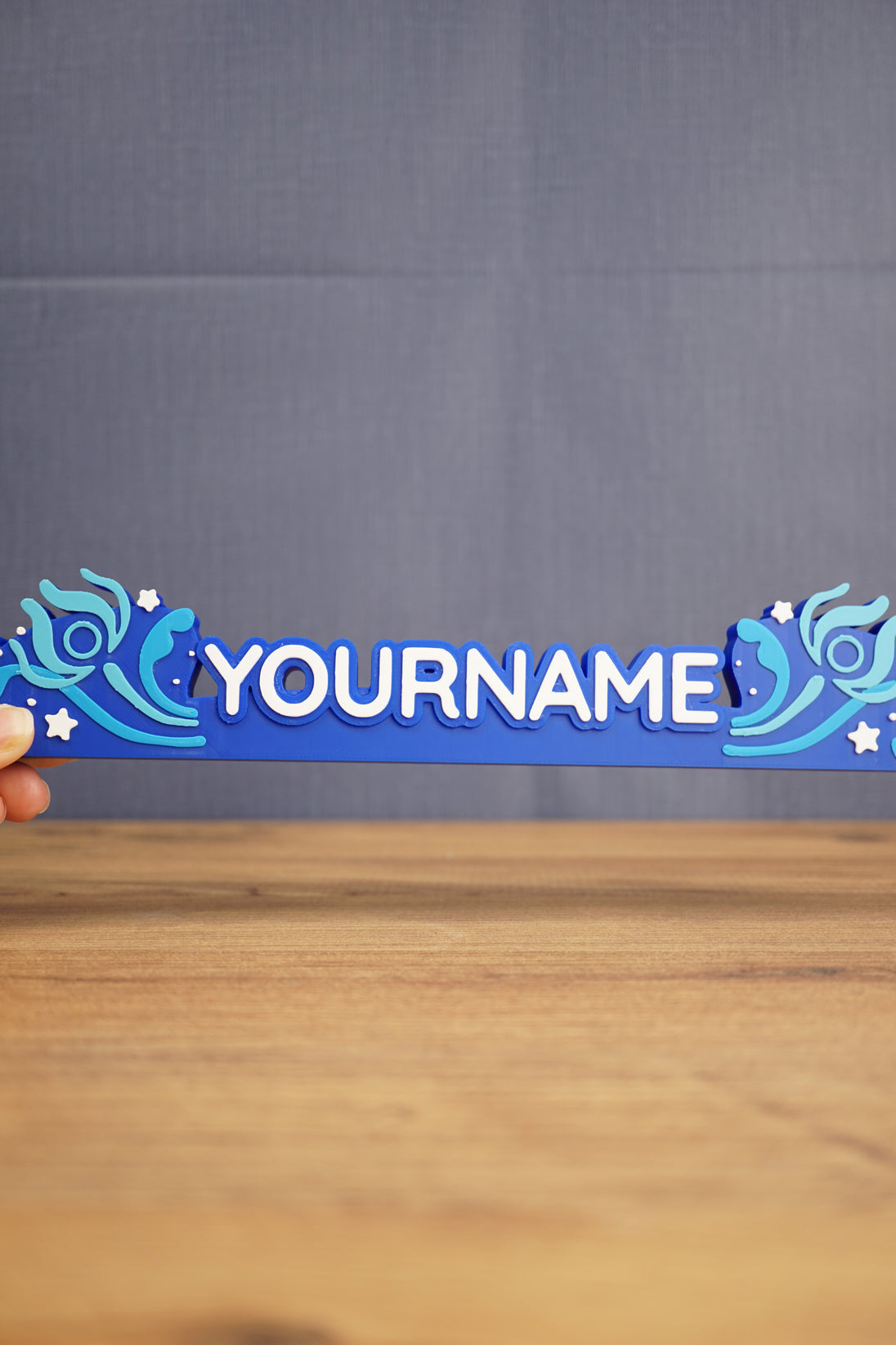 Hand-held blue One-in-Ten-Million style nameplate inspired by Palia, featuring custom white name lettering and fantasy star accents