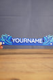 Hand-held blue One-in-Ten-Million style nameplate inspired by Palia, featuring custom white name lettering and fantasy star accents