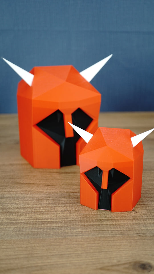 Two Dragon Med Helm display replicas in red, black and white, shown in 9cm and 15cm sizes for Old School RuneScape fans