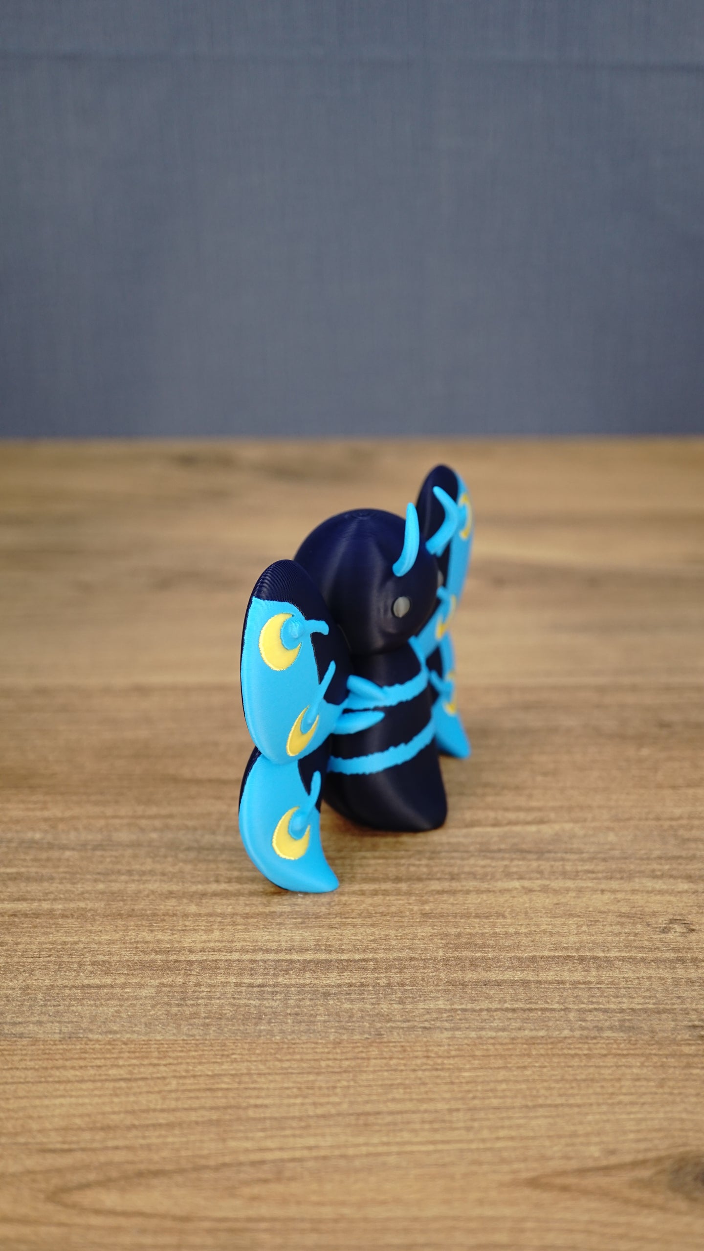 Side view of the Duskwing Butterfly decorative figure showing the layered wing shape, curved antennae and freestanding body design.