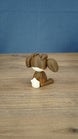 Rear view of the Elder Sernuk-inspired Palia plush figure showing its rounded head, ears, and cream tail.