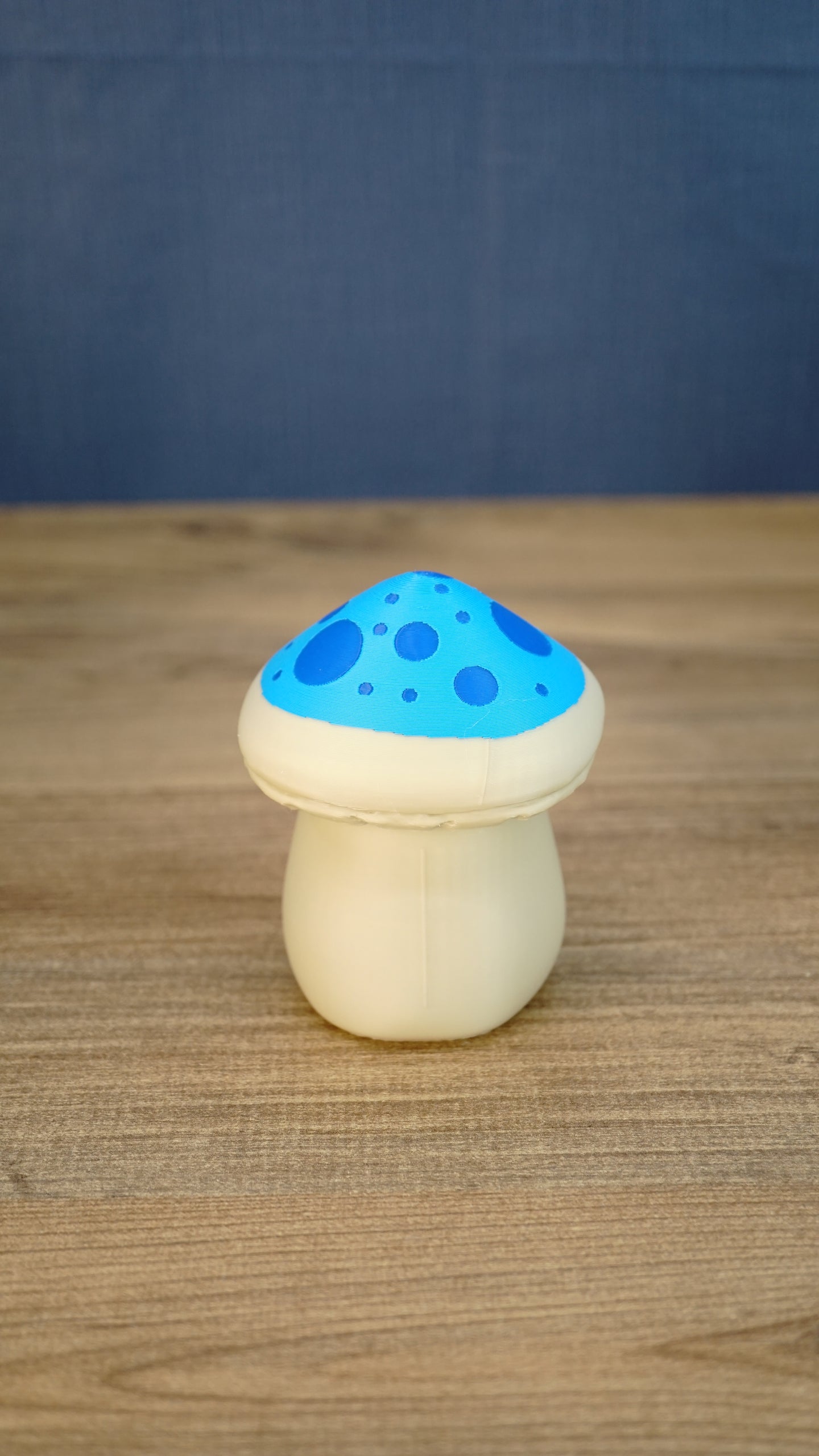Back view of the Elderwood Fun Guy figurine with a cream body and blue spotted mushroom cap