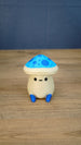 Front view of an Elderwood Fun Guy figurine with a blue spotted mushroom cap, cream body, black eyes, and blue feet.