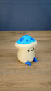 Side view of the Elderwood Fun Guy figurine showing its cream body, blue feet, and bright blue mushroom cap with darker blue spots.