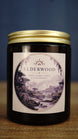 Elderwood vegan soy wax candle in an amber glass jar with gold lid, featuring moss, damp earth and cedarwood woodland fragrance.
