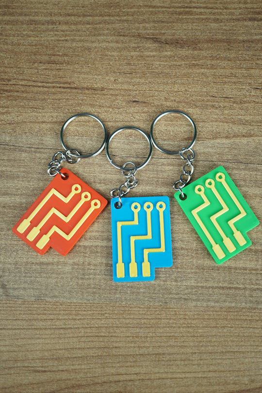 Factorio circuit keyring 3D printed with gold circuit design and gear logo