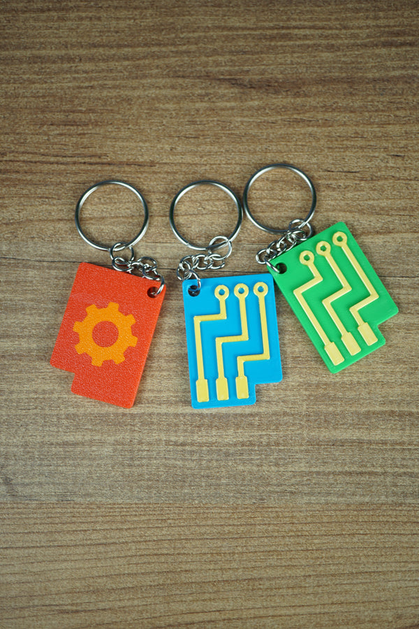 Close-up of Factorio circuit keyring showing orange embossed design