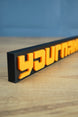 Factorio nameplate with bold orange lettering on black base