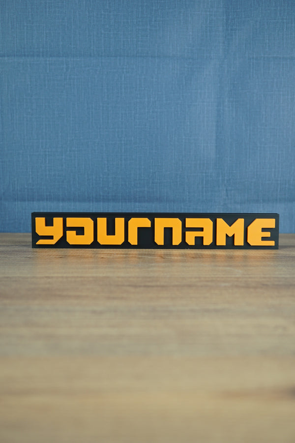 Factorio style nameplate 3D printed with orange text and black backplate