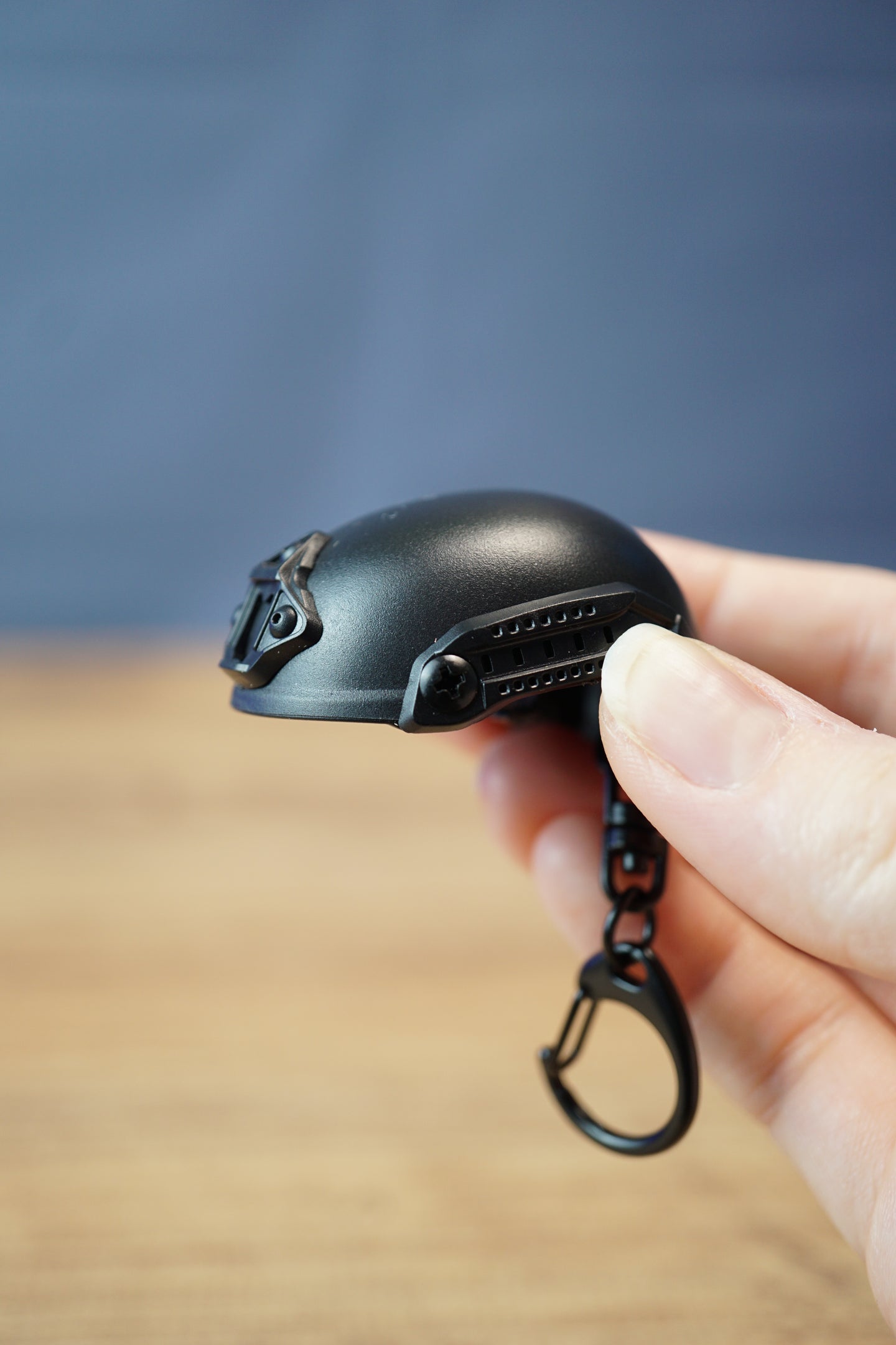Handheld FAST MT helmet bottle opener keychain with black tactical helmet styling, side rail details, and attached black keyring clip.