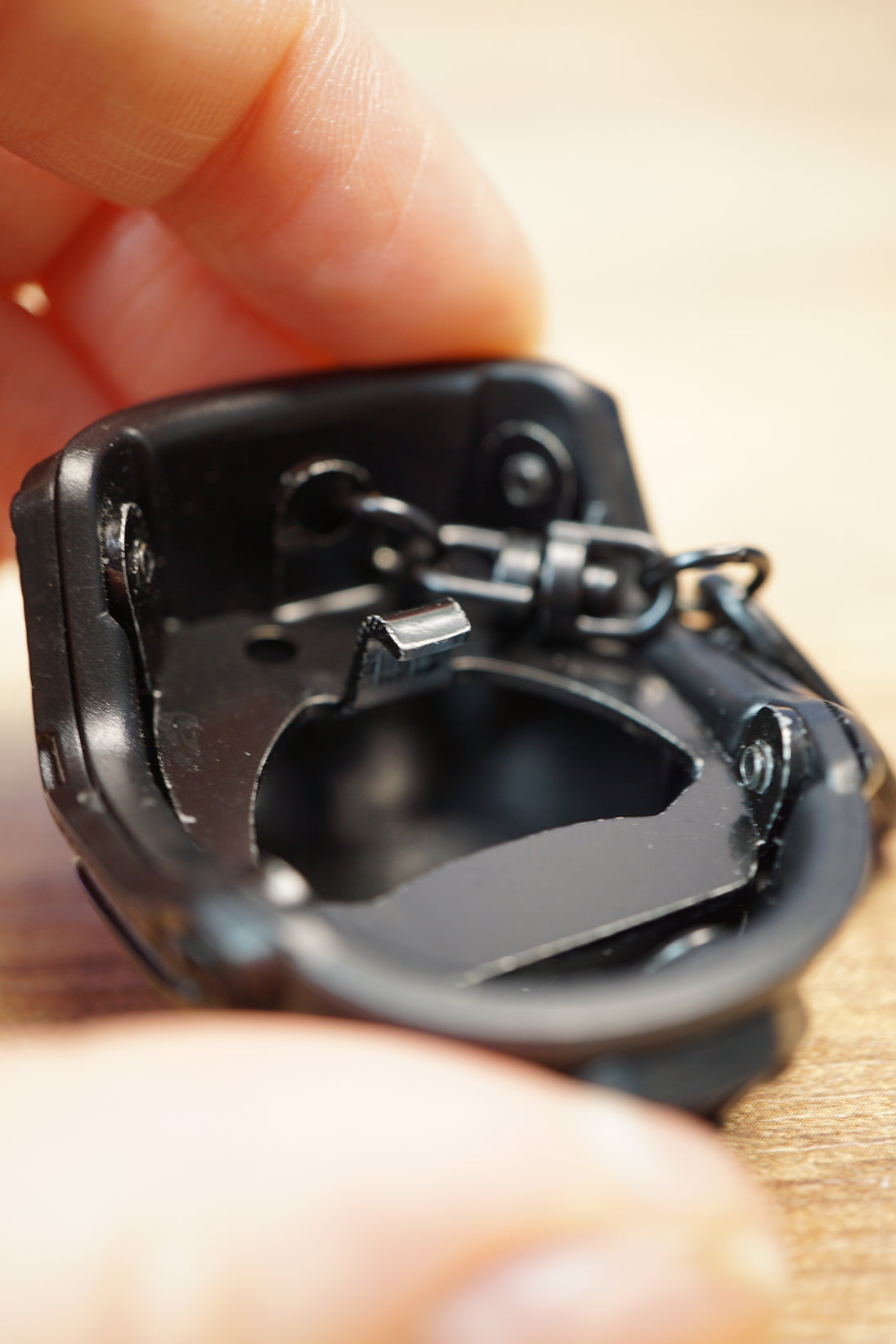 Detailed close-up of the FAST MT helmet bottle opener interior with black metal finish, opener edge, keyring hardware, and compact accessory design.