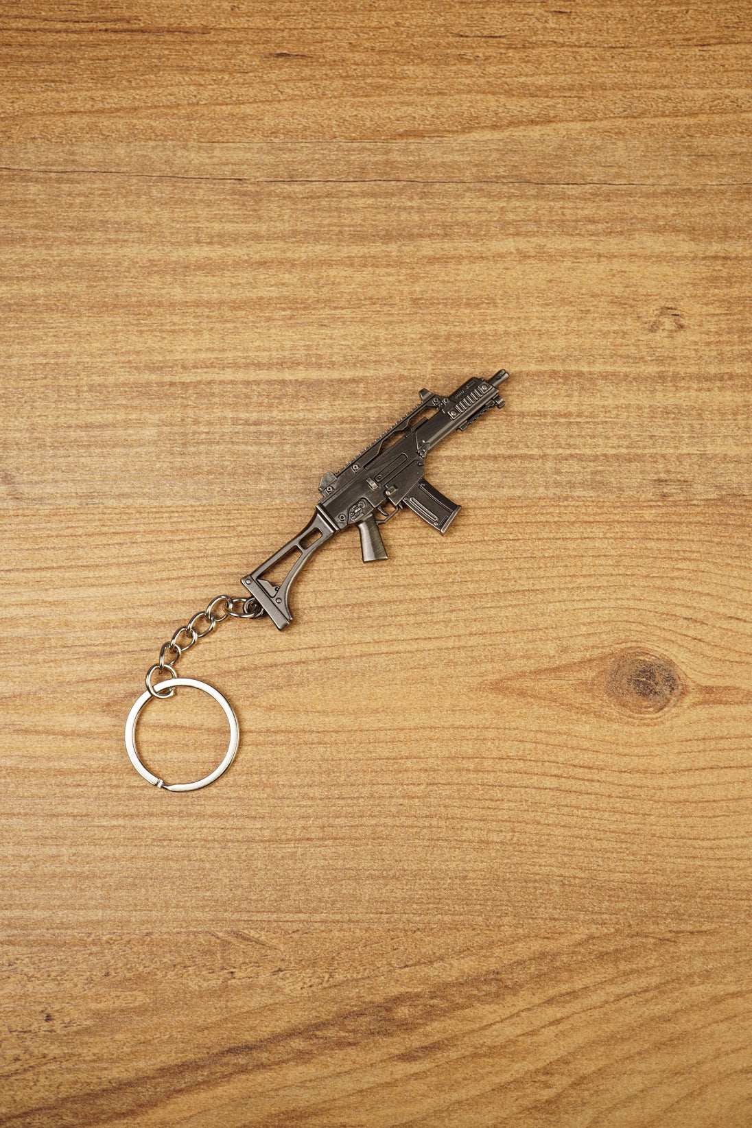 Detailed HK G36 keychain displayed diagonally on wood, metal rifle keyring gift for military game and shooter fans
