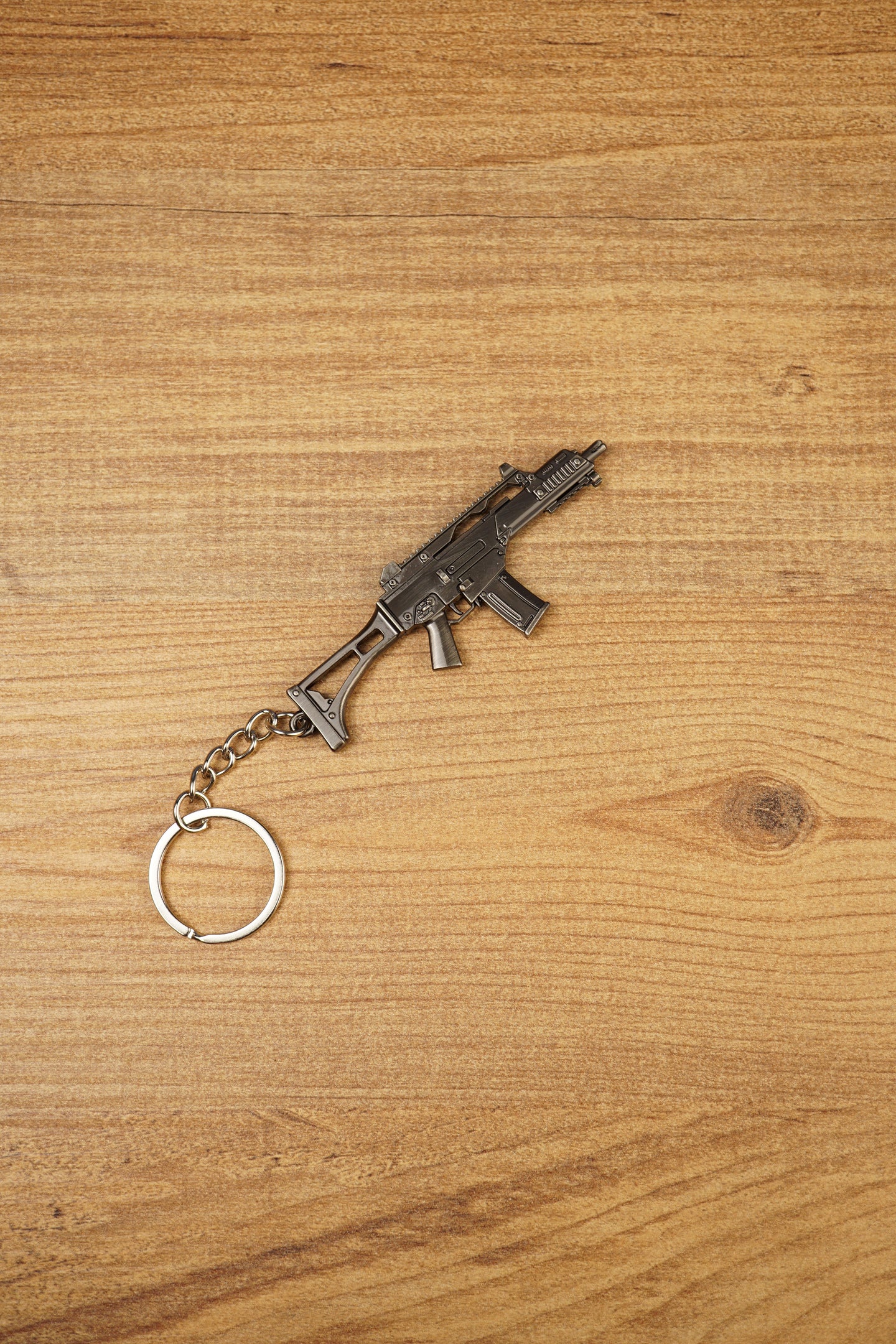 Detailed HK G36 keychain displayed diagonally on wood, metal rifle keyring gift for military game and shooter fans