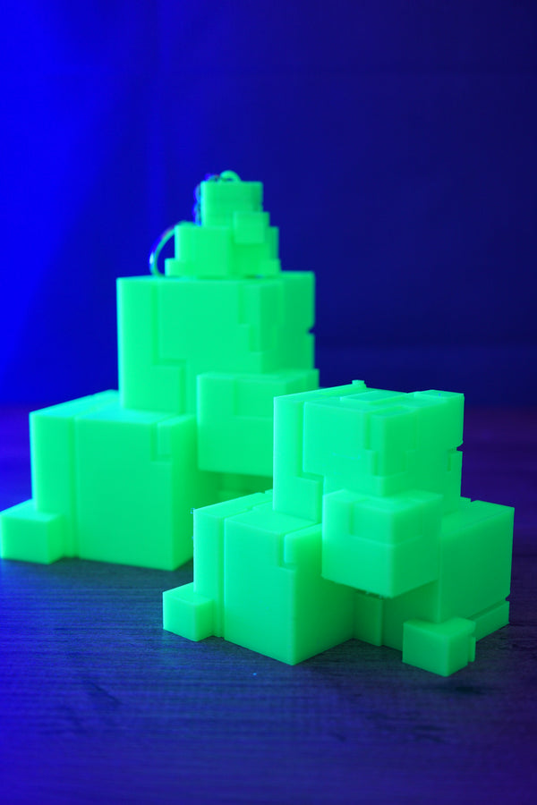 Glow in the dark Subnautica ion cube replicas under blue lighting, showing bright green sci-fi cube collectibles on a tabletop.