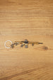Gold tactical rifle keyring with detailed sight, magazine and barrel shown on wood as a gaming backpack charm.
