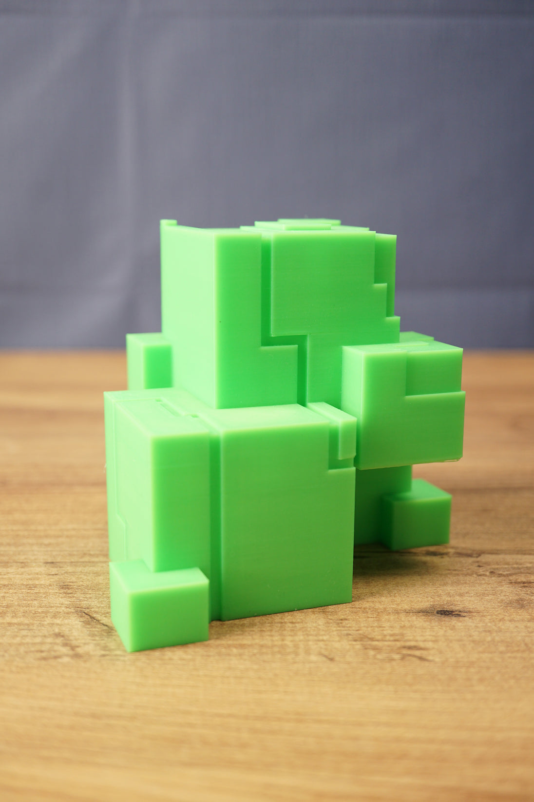 Close-up of a green Subnautica ion cube replica with blocky alien-style shape, square details, and clean tabletop product display.