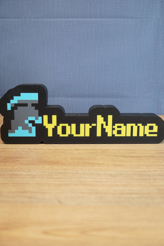 Custom RuneScape-style group ironman nameplate with a blue and grey helmet icon, yellow lettering, and black frame displayed on a wooden tabletop.