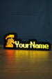 Glowing hardcore group ironman desk sign with red and grey helmet icon, yellow custom lettering, and warm reflection across the tabletop.