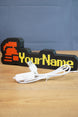 Hardcore ironman RuneScape-inspired nameplate shown with USB cable, red helmet icon, yellow lettering, and black casing on a wooden surface
