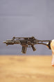 Close-up of HK G36 metal rifle keyring held between fingers, showing miniature tactical details and keychain size