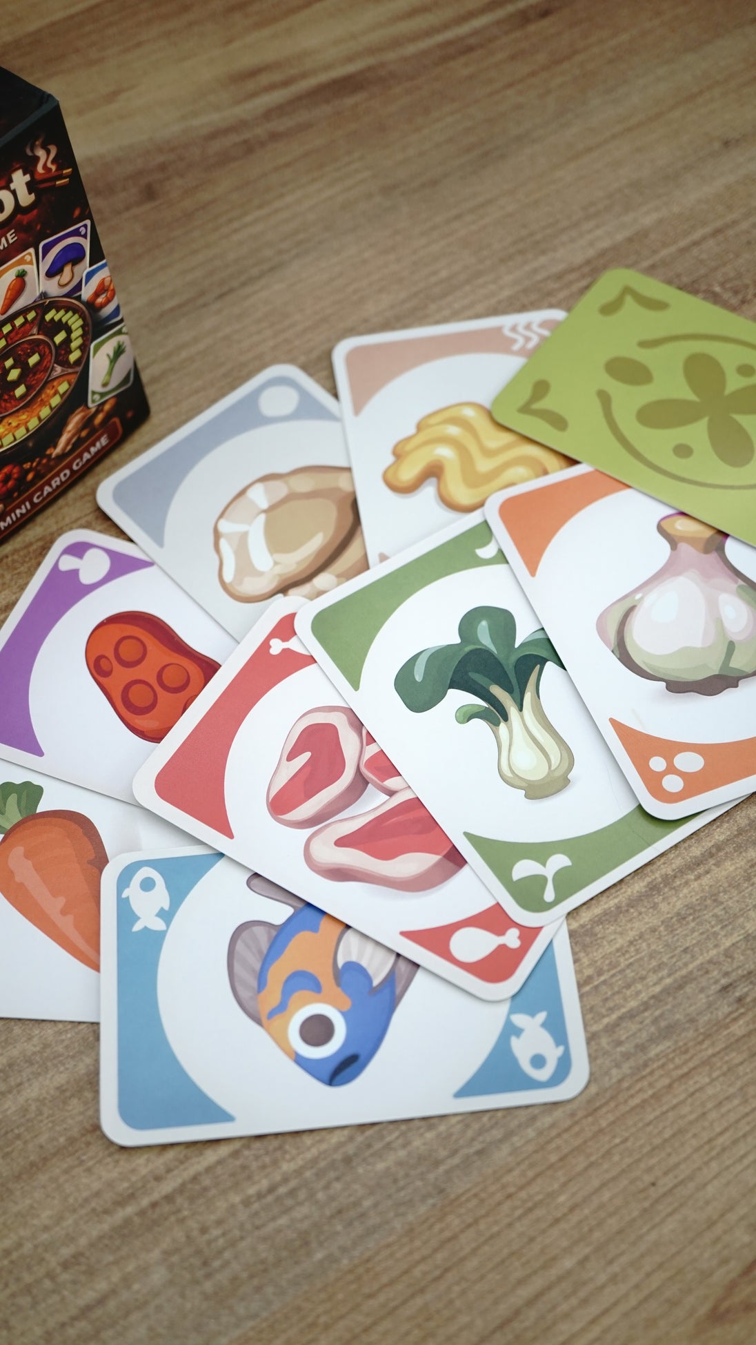 Close-up of colorful Hotpot ingredient cards featuring fish, meat, mushrooms, vegetables, garlic, noodles, and other food categories.