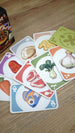 Close-up of colorful Hotpot ingredient cards featuring fish, meat, mushrooms, vegetables, garlic, noodles, and other food categories.