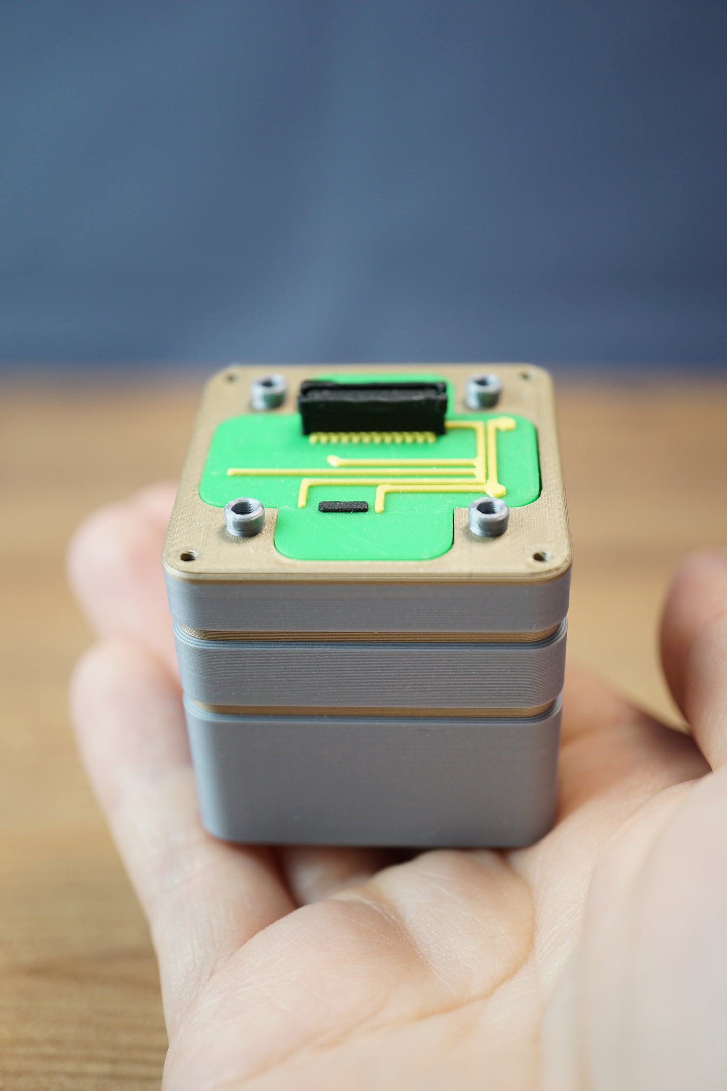 Compact Iridium thermal vision module replica displayed in hand, featuring grey layered casing, green circuit board design, and detailed top connector.