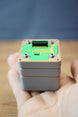 Compact Iridium thermal vision module replica displayed in hand, featuring grey layered casing, green circuit board design, and detailed top connector.