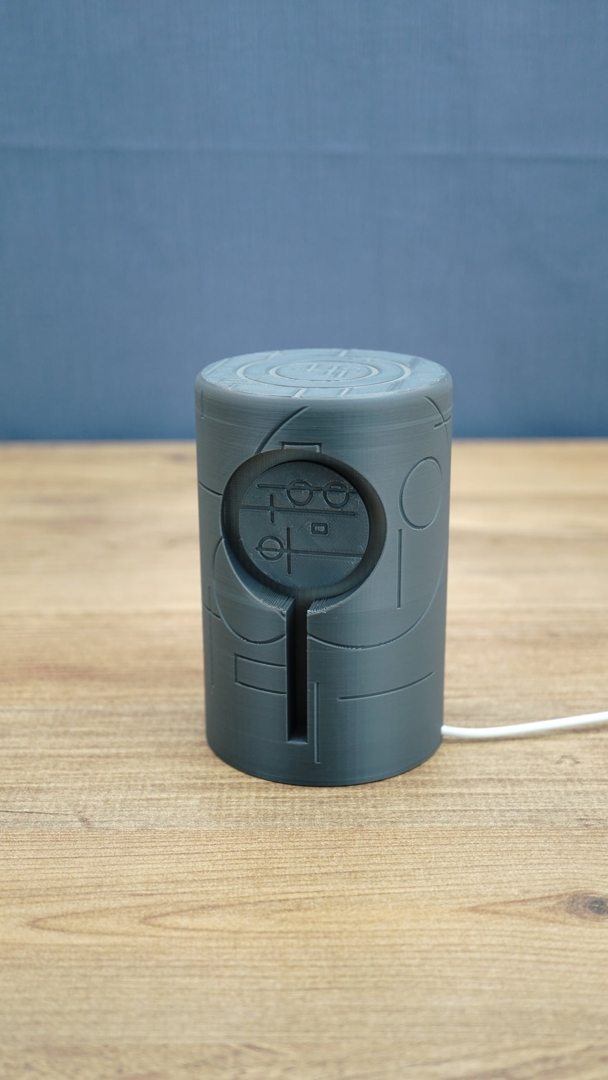 Front view of the No Man’s Sky inspired Knowledge Stone lamp showing the circular alien symbol design, dark grey housing and USB power cable.